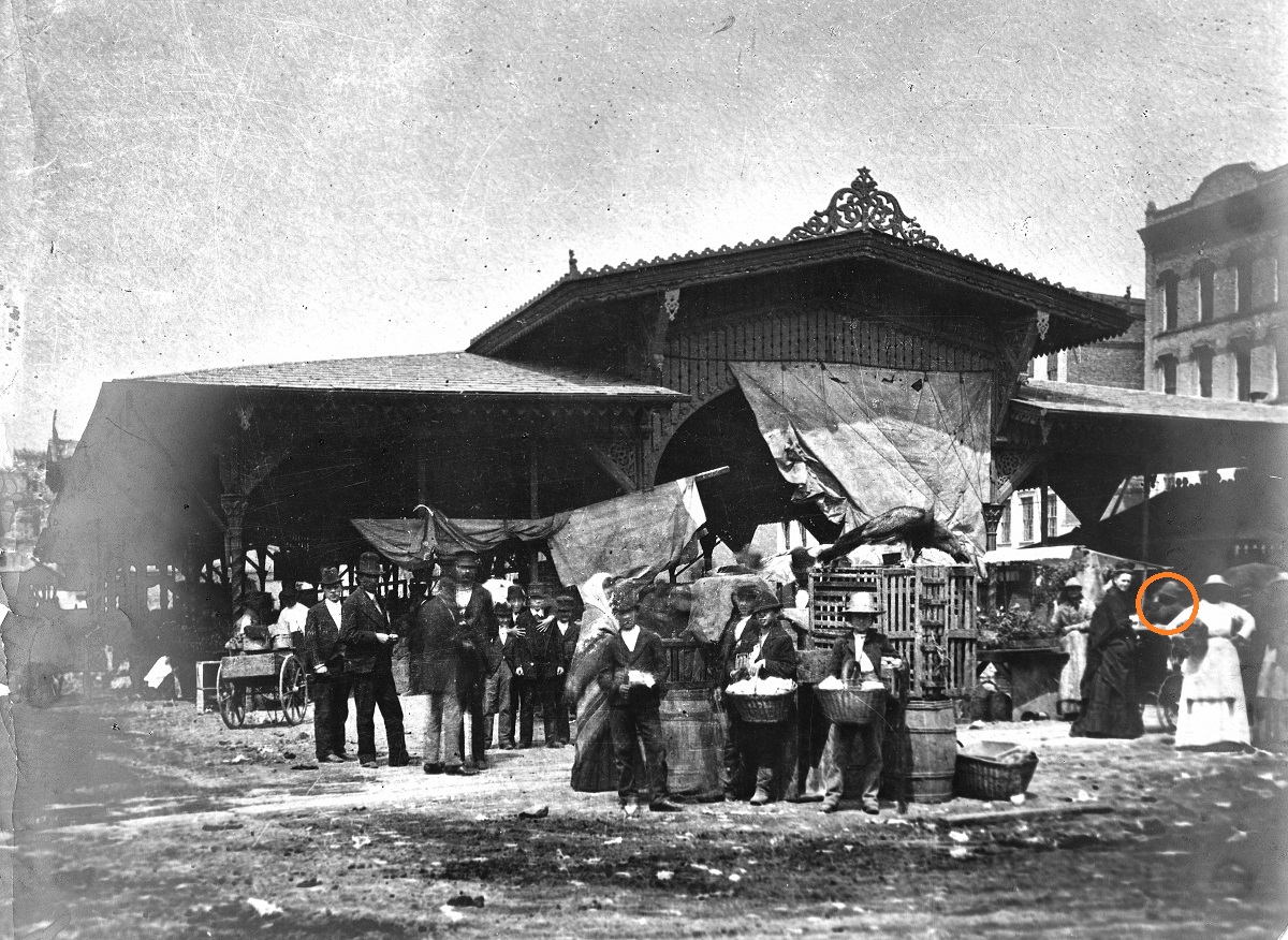 Vegetable Shed at Detroit’s City Hall Market Large open-sided building with vendors selling wares to people outside