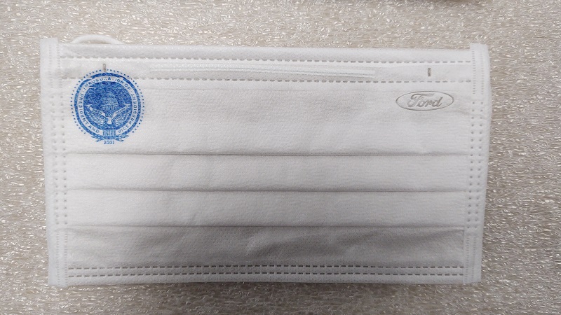 White face mask with blue presidential insignia in one top corner and blue oval "Ford" logo in the other