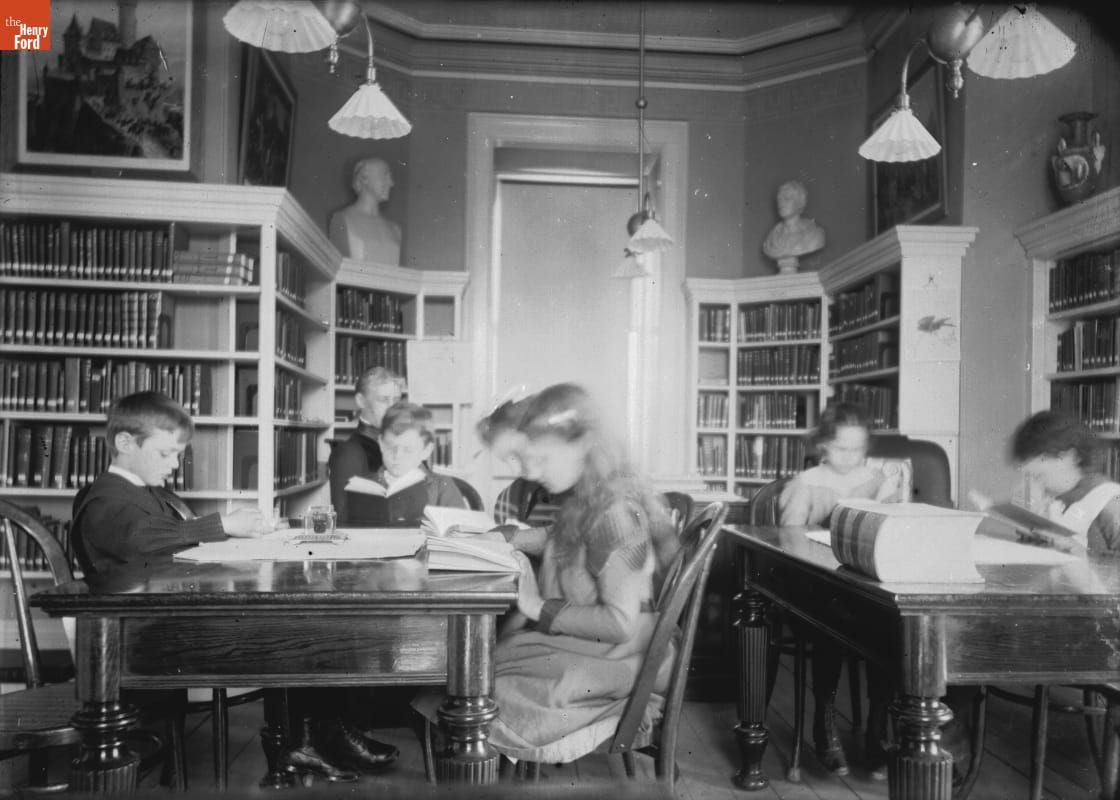 Newark Library, 1901-1915 Photo taken by Jenny Young Chandler of young people sitting at tables and reading in the Newark library