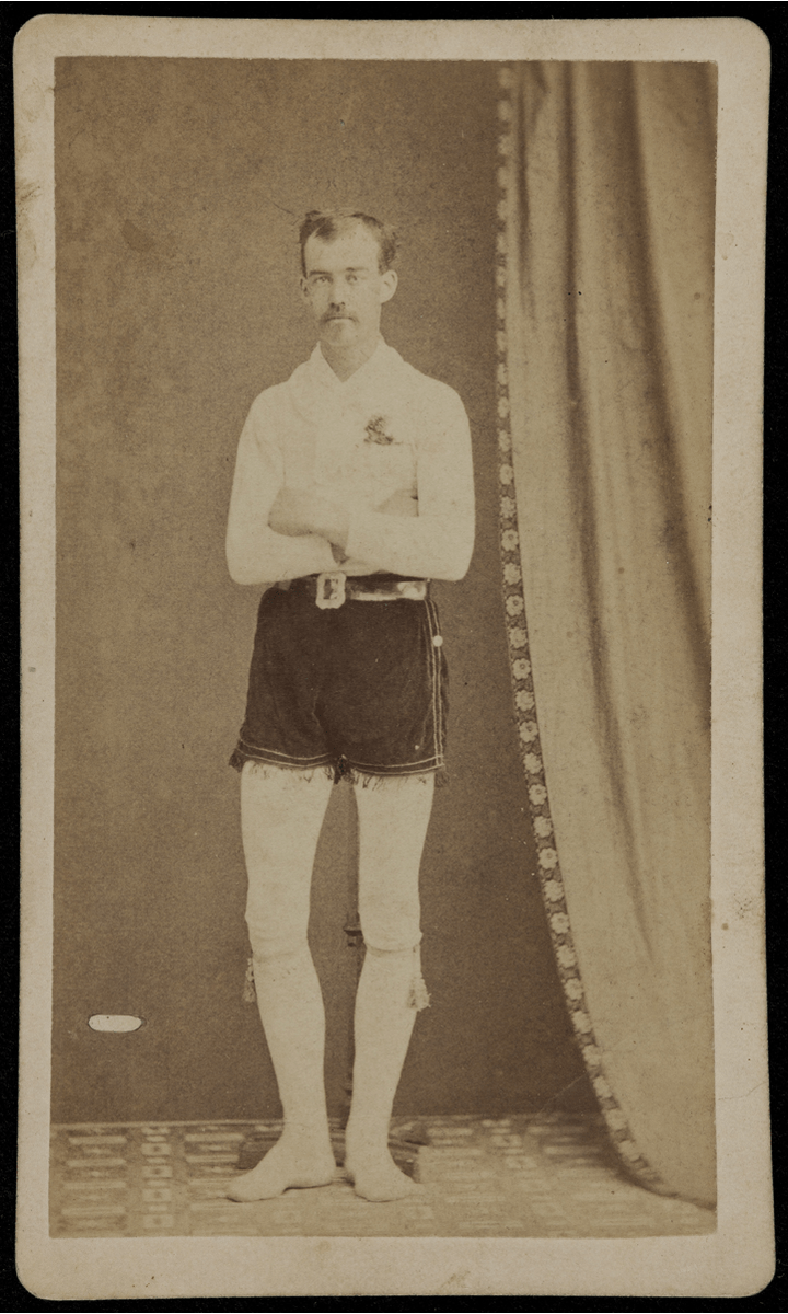 Unidentified, Charles Gore, Jack Shaw, and W. E. Drew of the Alert Hose Company GIF cycling through four black-and-white photos of men standing with arms crossed, wearing white long-sleeved shirt, white tights (?), and dark velvet shorts with fringe