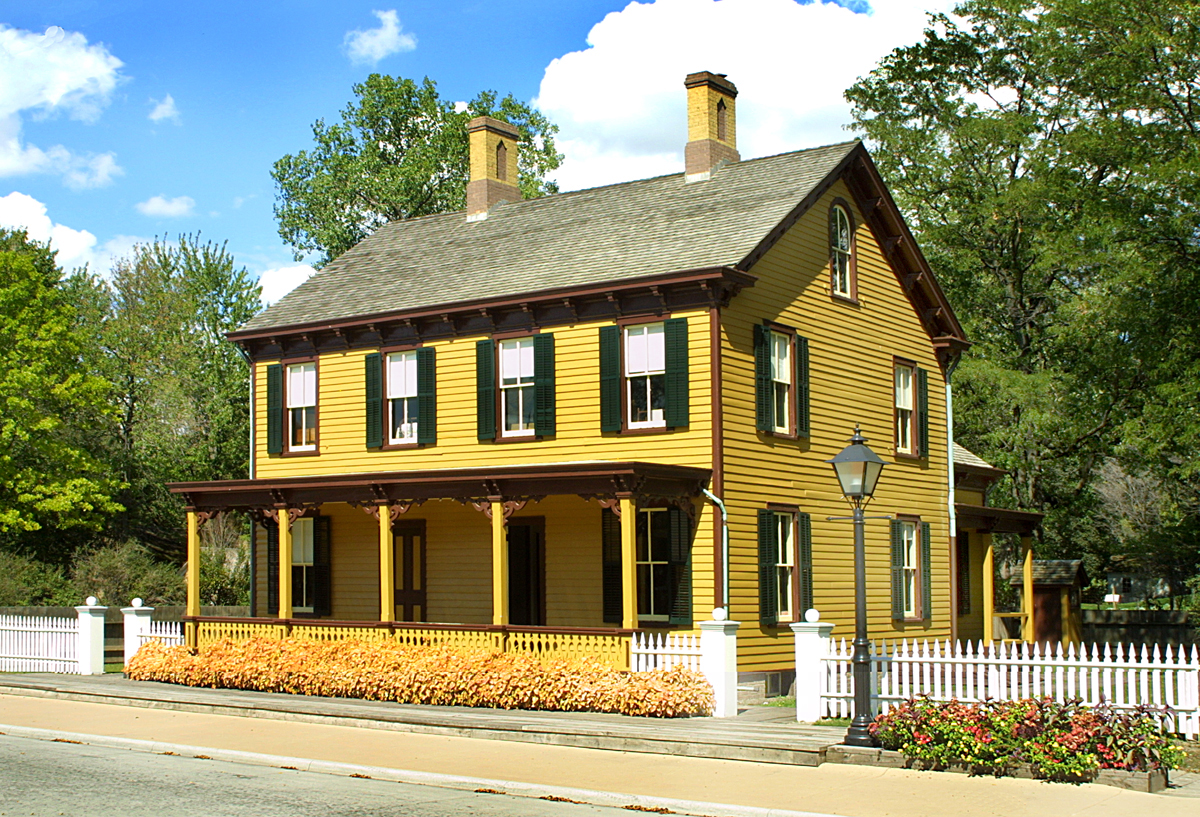 Sarah Jordan Boarding House Two-story yellow wooden building with white picket fence in front