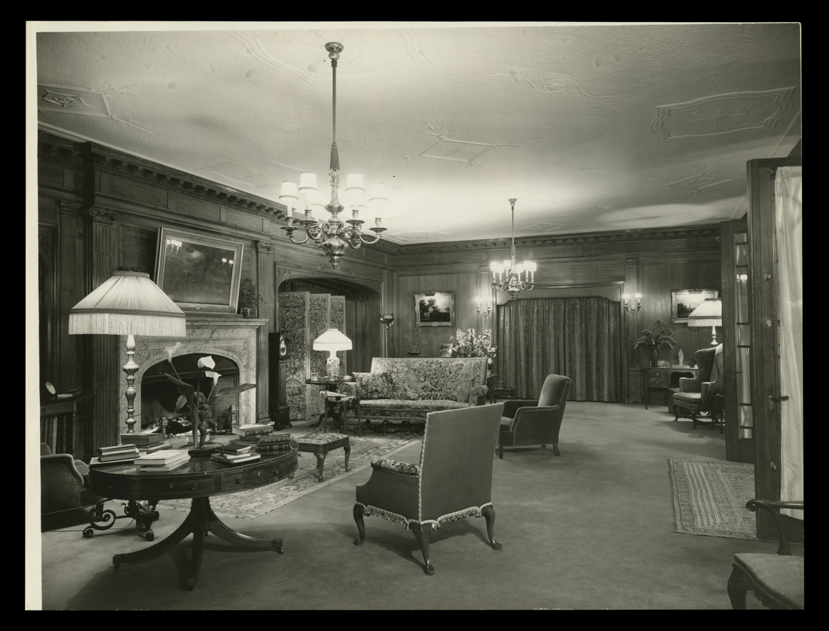 Room interior with couch, chairs, tables, and what appear to be French doors at one side THF136074