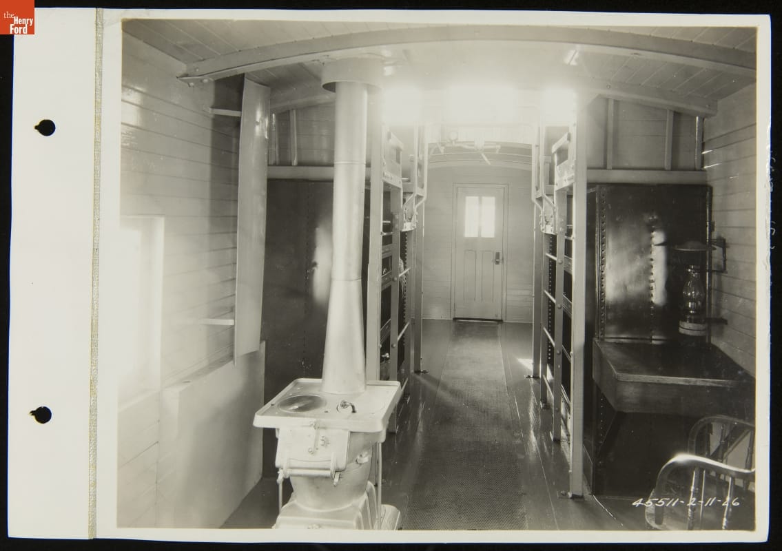 Interior of a Railroad Caboose, Detroit, Toledo & Ironton Railroad, February 1926 Interior of railcar, with stove, desk and chair, and shelving visible
