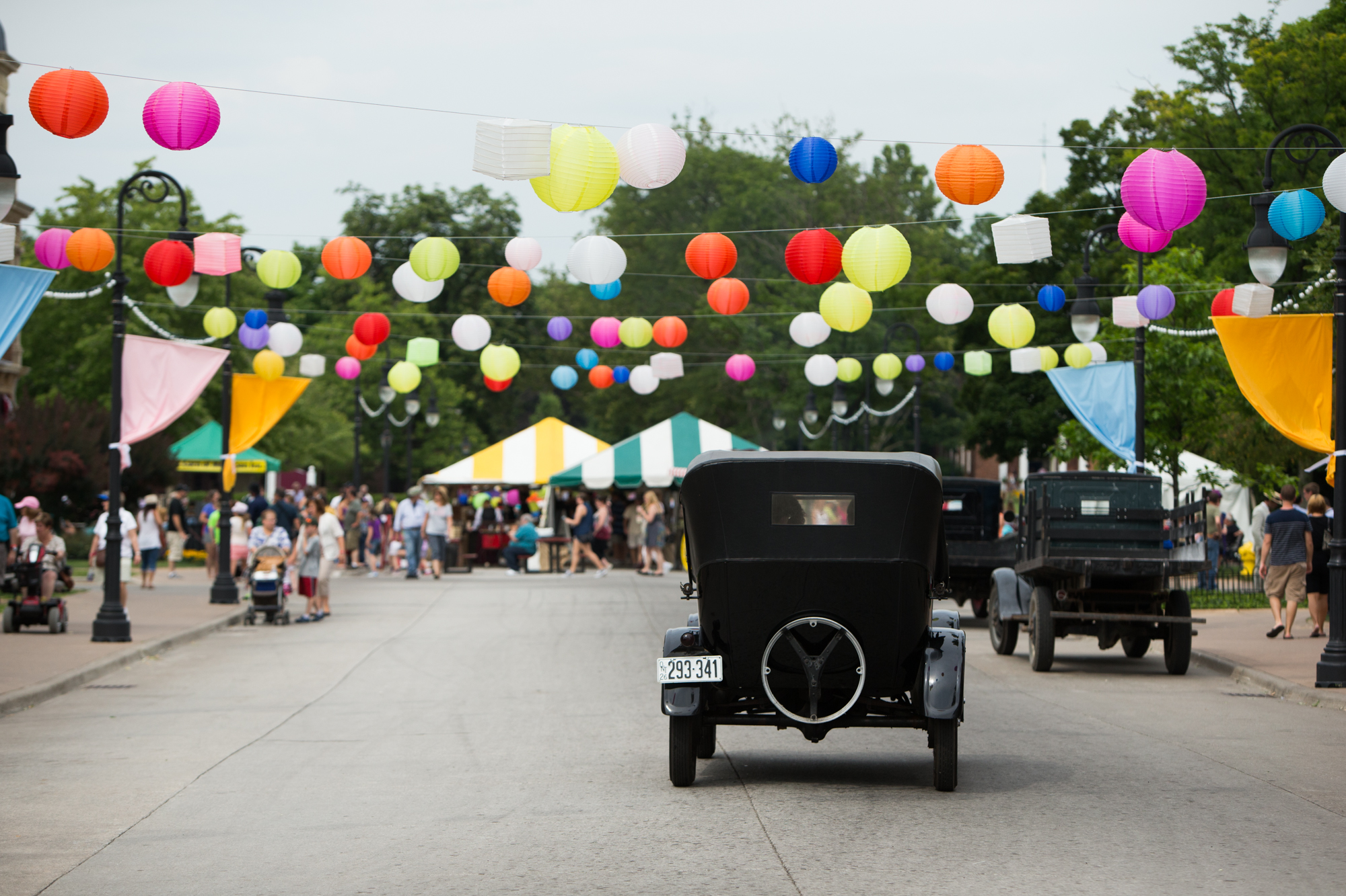 Old Car Festival Antique car driving down a street festooned with balloons