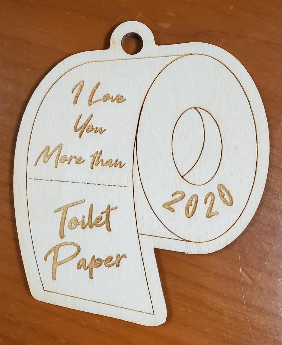 Wooden cut-out in the shape of a roll of toilet paper; contains text