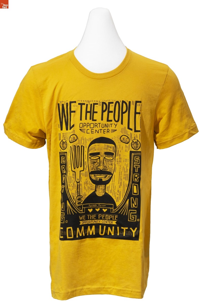 "We the People Opportunity Center" T-Shirt, circa 2019 Yellow t-shirt with black caricature drawing of a man with large fork along with text and images