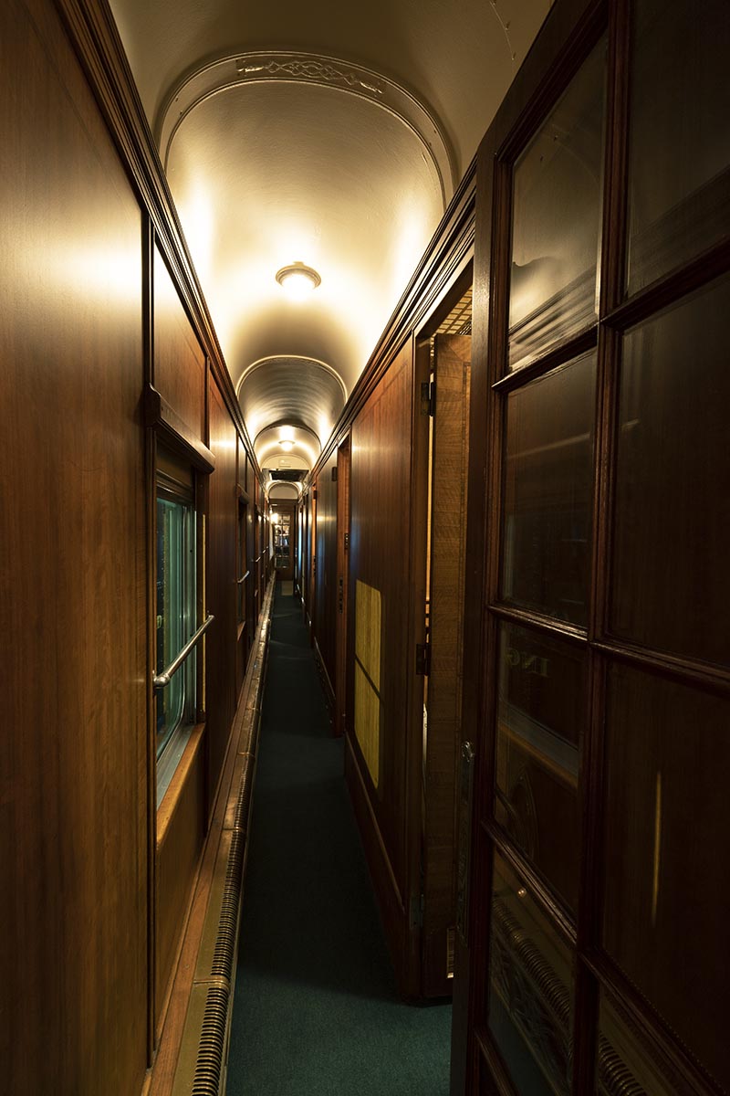 Fair Lane railroad car hallway Narrow wood-paneled hallway with arched ceiling