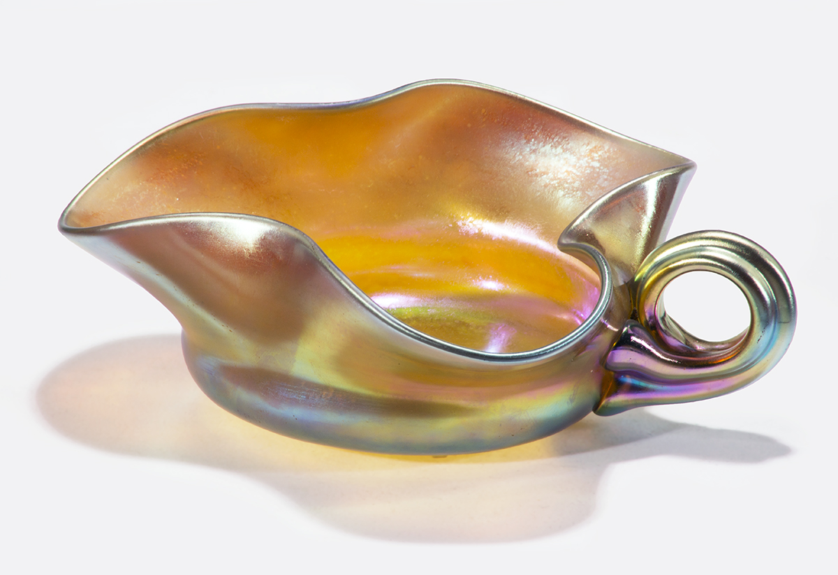 Aurene Sweetmeat Dish, 1903-1930 Iridescent glass leaf-shaped dish in with curved handle; amber in color