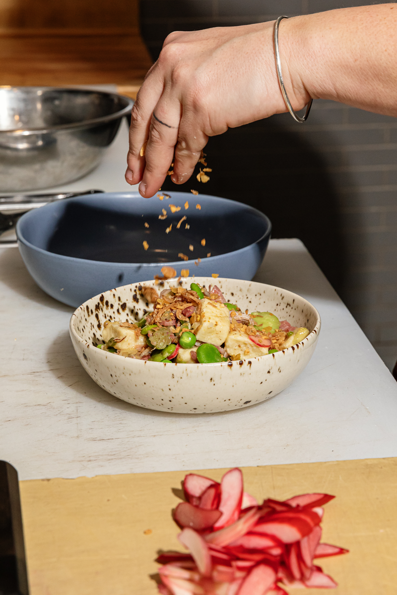 Picture of Chef Sarah Welch's hands plating a dish for guests at MARROW