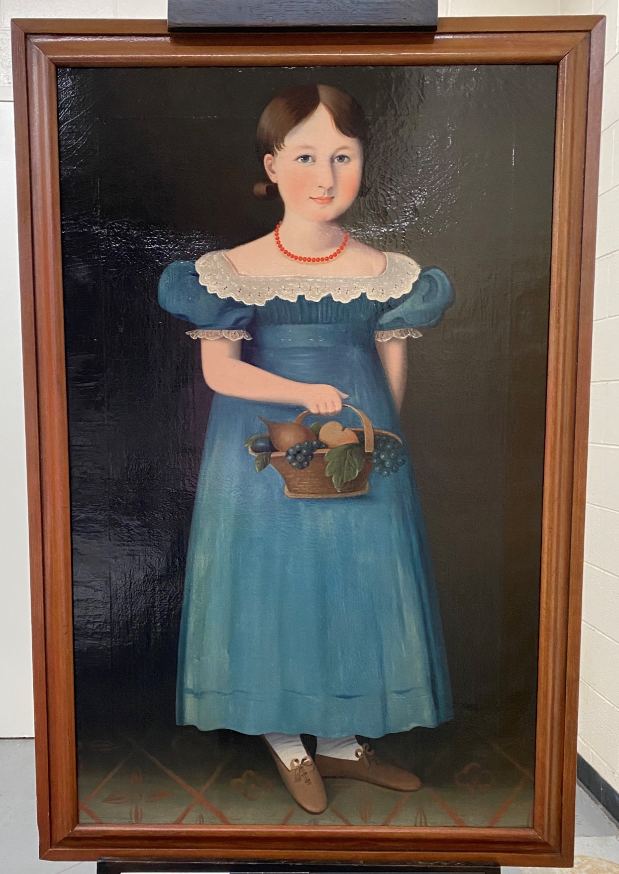 The completed painting after conservation Framed painting of girl in blue dress holding basket of fruit
