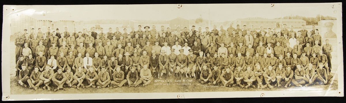 Civilian Conservation Corps Company No. 1614, 1934 Panoramic photograph of large group of people, posed sitting and standing, many in uniform