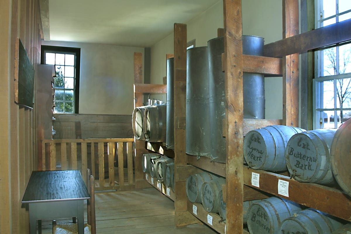 Dr. Howard's Office / interior Narrow room with built-in racking filled with casks and vats labeled with hand-written text