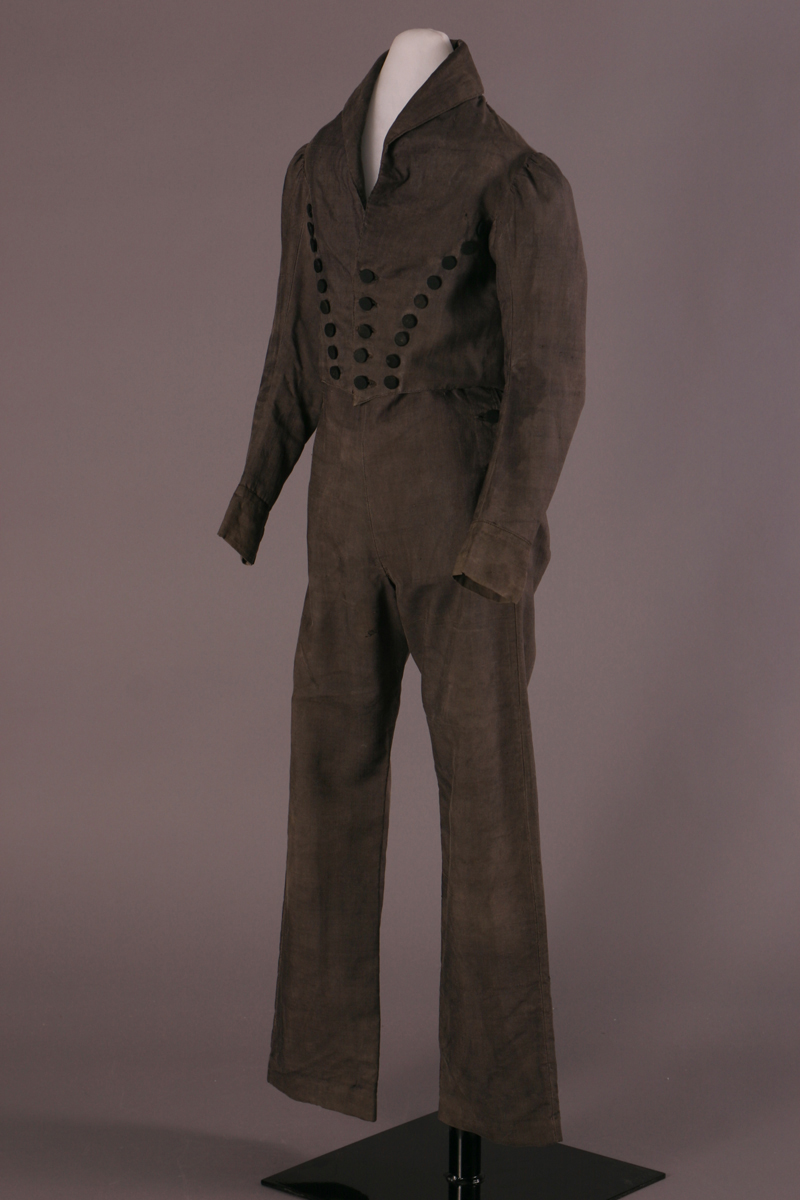 Boy's Suit, 1820-1830 Dark gray suit with simple pants and a jacket with several rows of large black buttons converging at the waist in a W shape