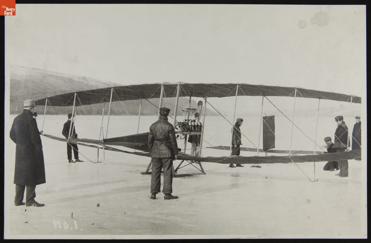 Before the 319-Foot Flight of "Red Wing," Lake Keuka, March 12, 1908 Black-and-white photo of an early glider on snow or ice with a number of people around it