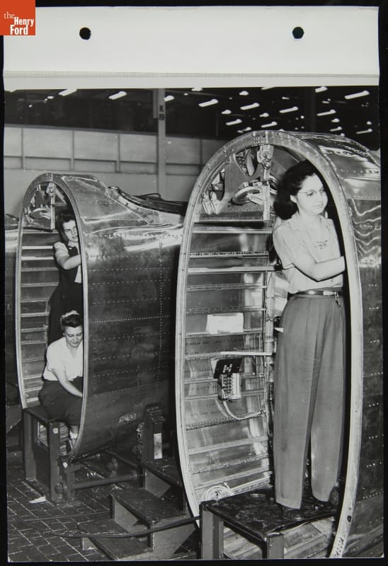 Women Riveting Tail Cones, Willow Run Bomber Plant, June 1944 Three women work inside large, oval metal shapes