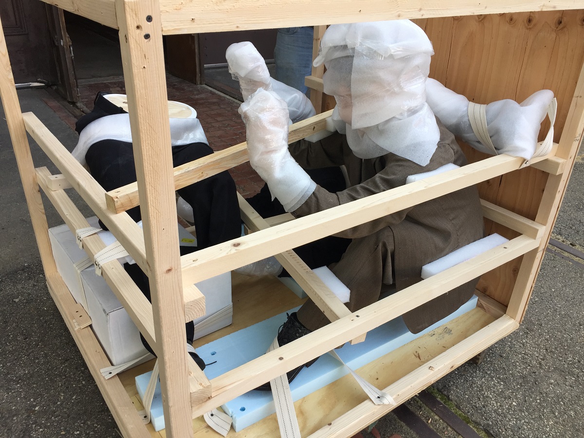 Mannequins of Henry Ford and Spider Huff in crate Open crate with two human-like figures swaddled in packing material