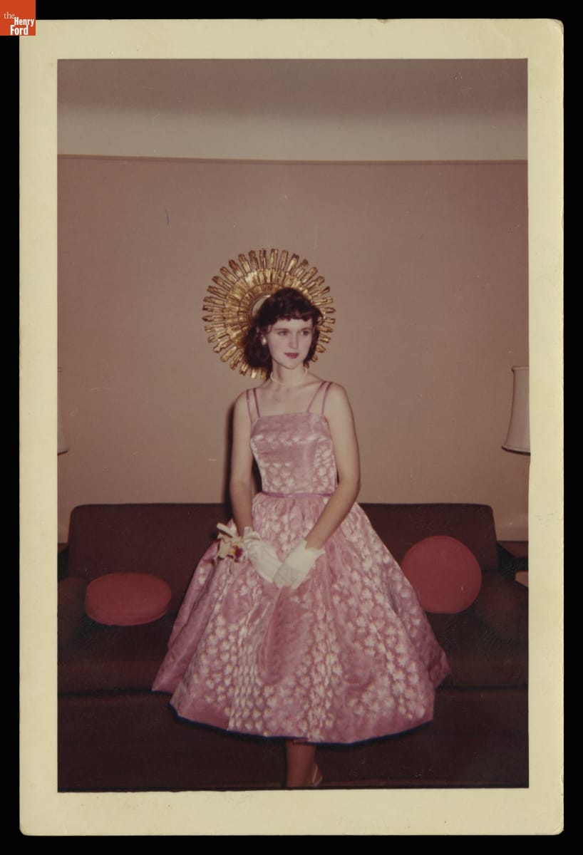 Patricia Jean Davis before Her Prom, 1960 Woman in pink sleeveless dress with full skirt, wearing white gloves, poses in front of a couch