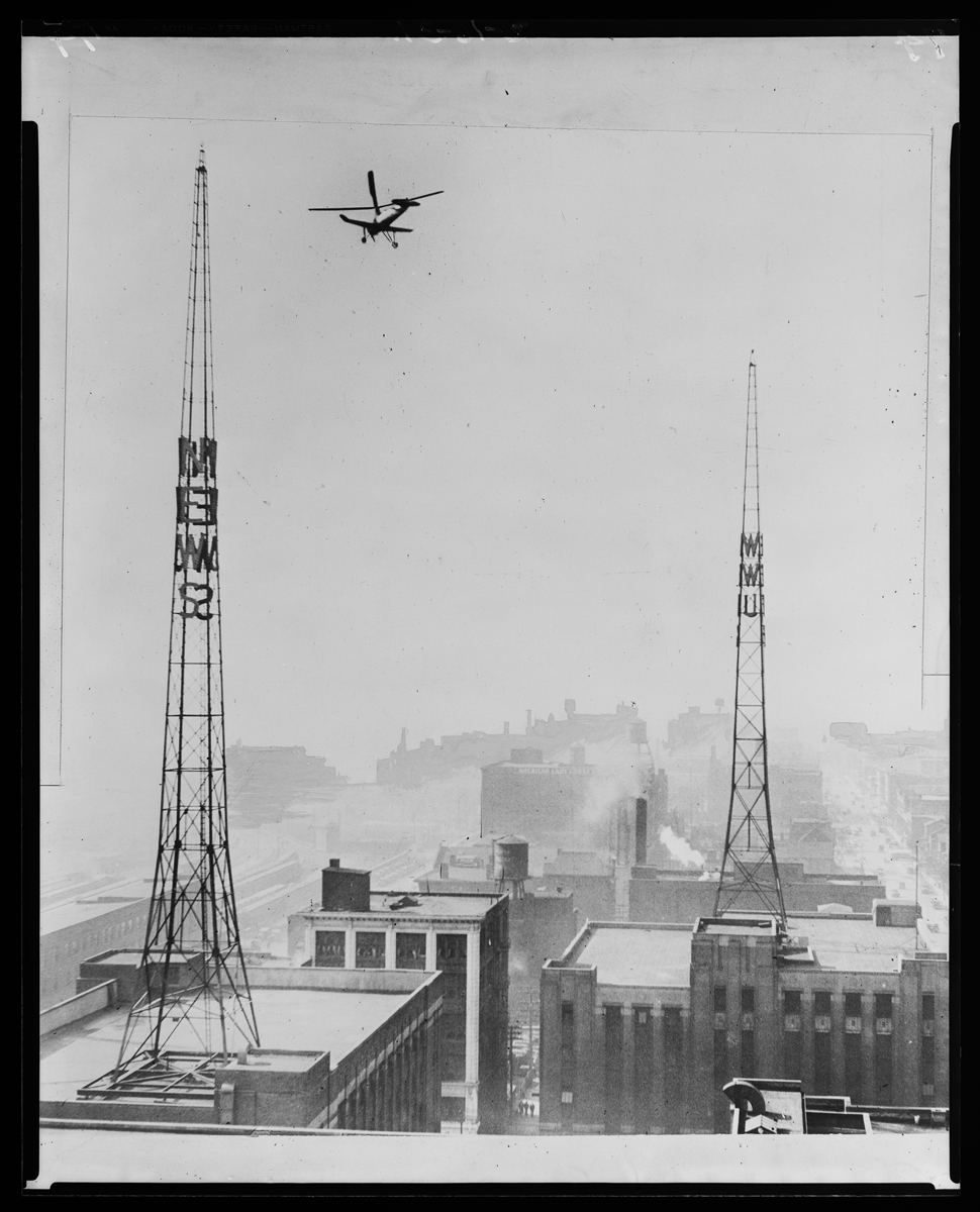 Detroit News--Autogiro--Over WWJ Towers Aircraft flying over towers and buildings