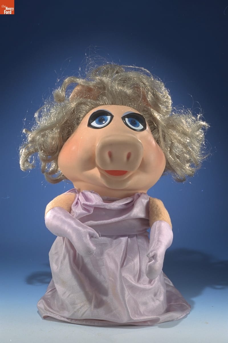Miss Piggy Hand Puppet, 1981-1982 Puppet of pig with blonde hair wearing purple dress and purple shoulder-length gloves