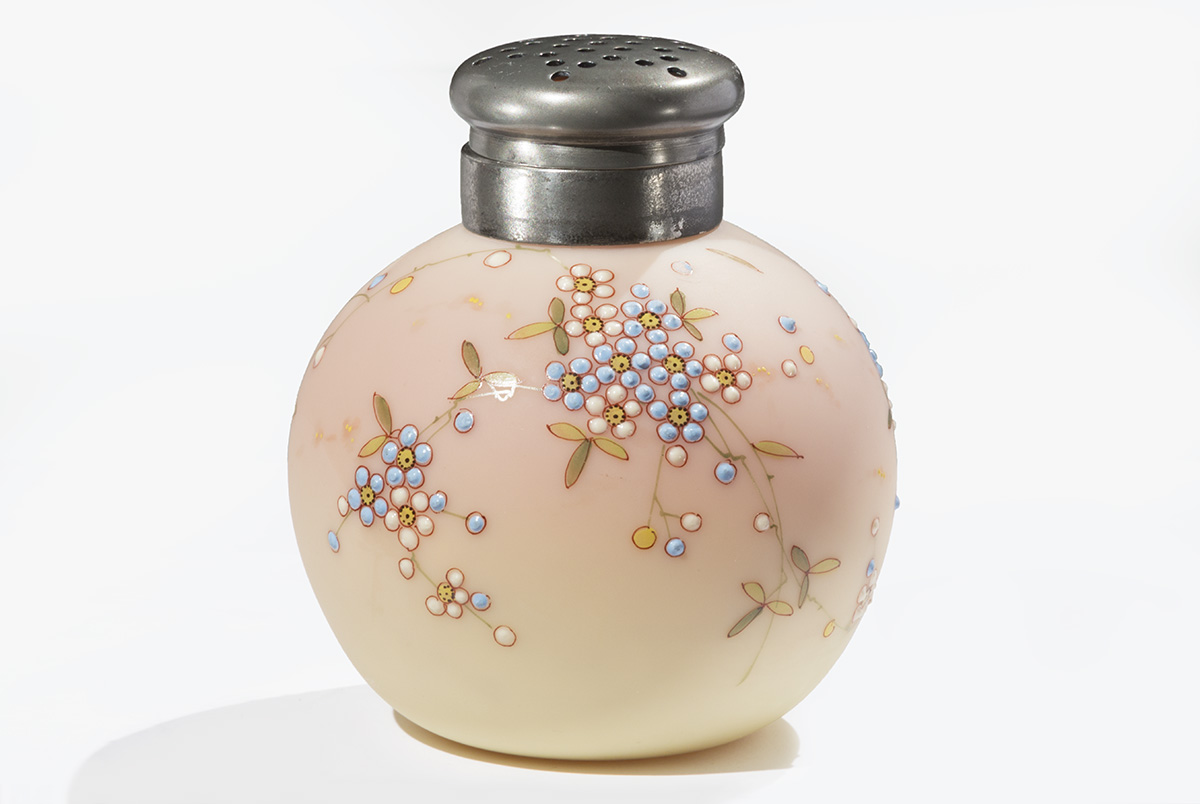 Burmese Caster, 1885-1895 Small round, peach/cream-colored ceramic jar with pattern of stippled flowers, topped with a silver "shaker" lid