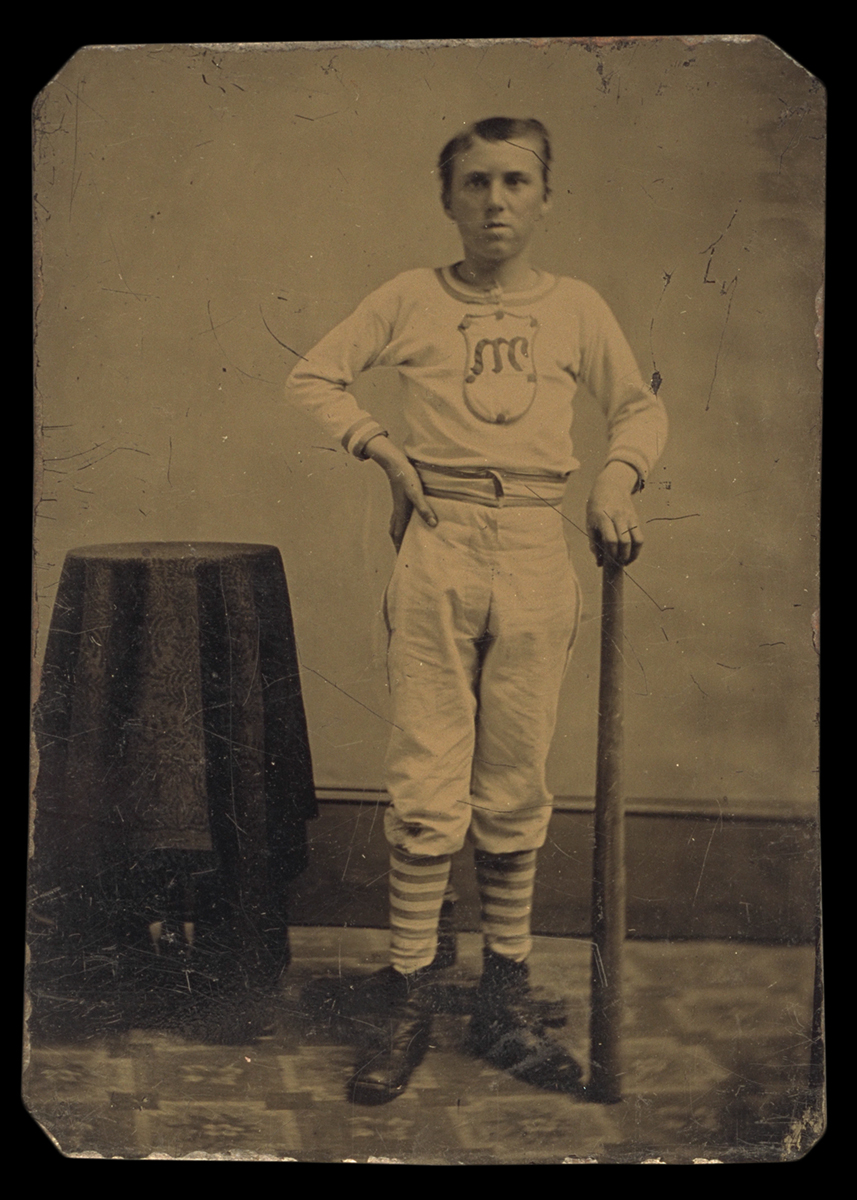 Portrait of a Baseball Player, circa 1880 Man in baseball clothes holding bat, standing next to small table