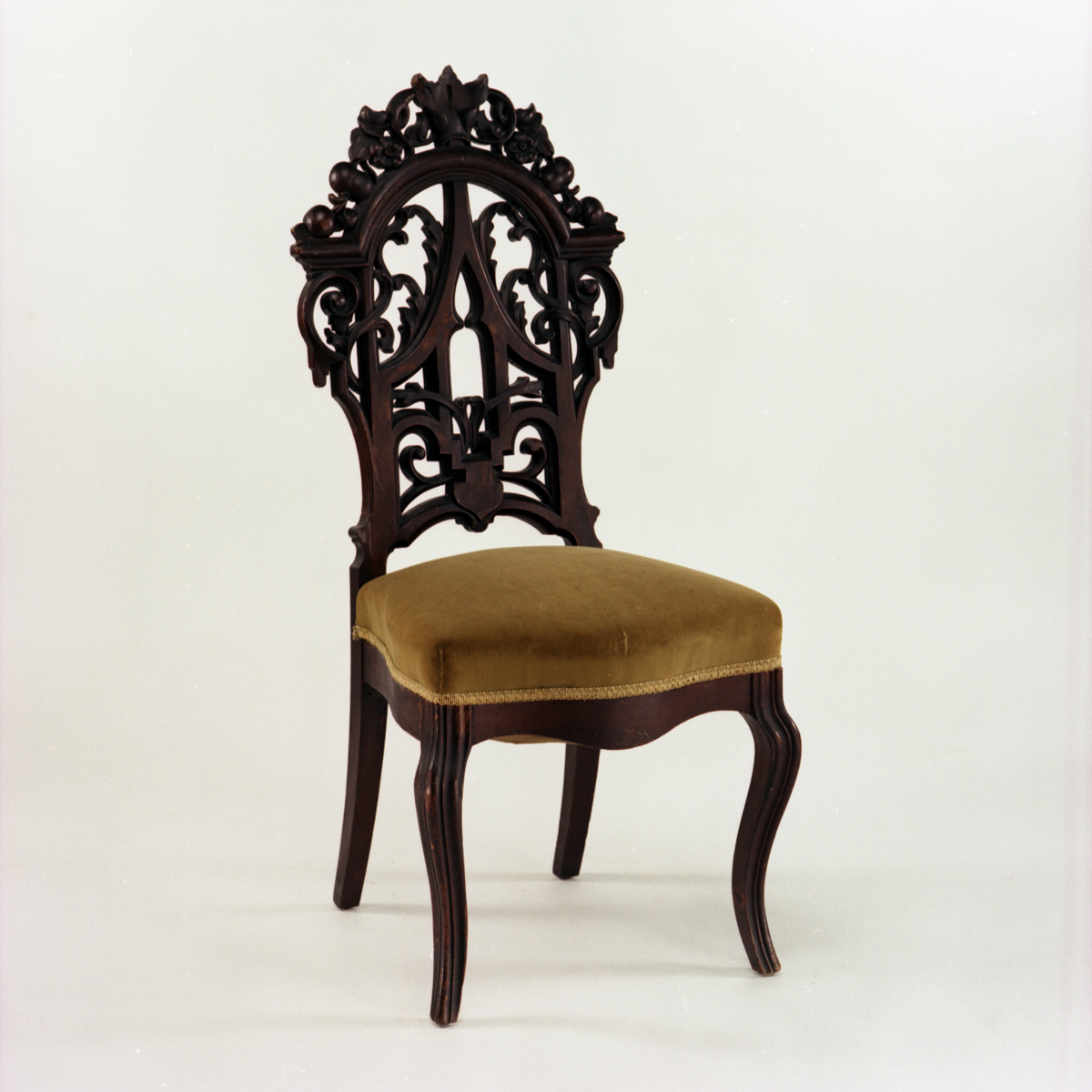Side Chair, 1855-1870 Chair with mustard yellow velvet seat cushion and intricately carved dark wood back