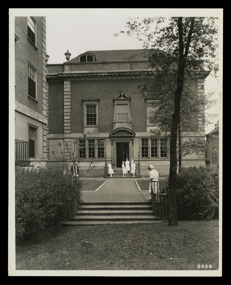 Henry Ford Hospital, Detroit, Michigan, May 1931 Entrance to brick building, with walkway and several people wearing nurses' uniforms outside