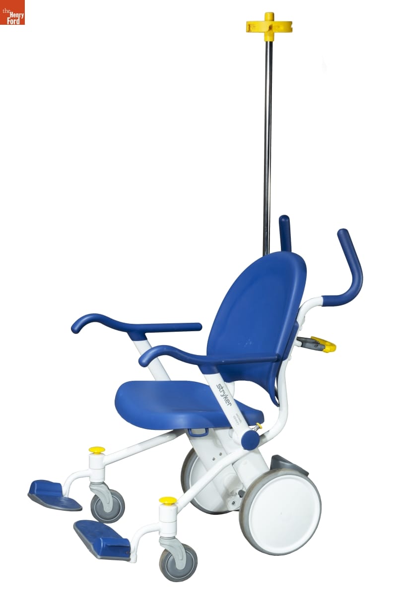 Stryker Prime TC Transport Chair, 2013 Wheelchair with white plastic frame and blue plastic seat and seat back