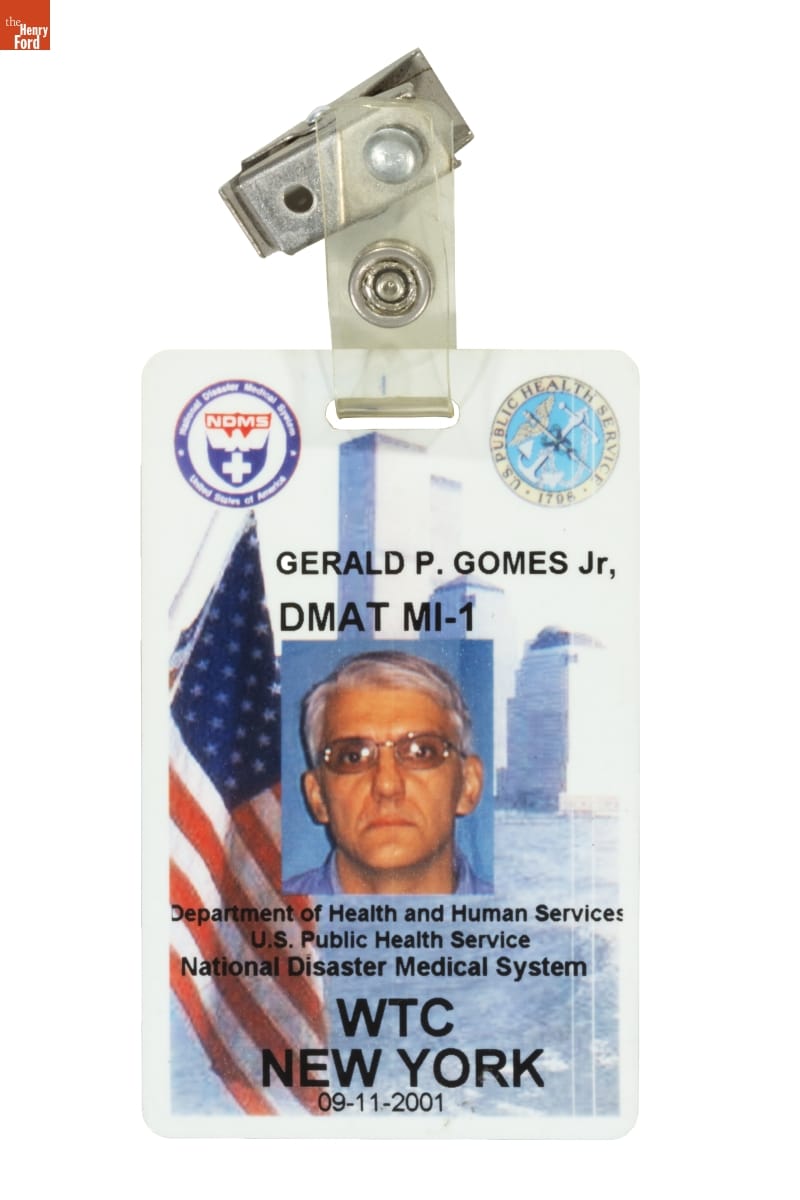 Identification Badge, Worn by Gerald Gomes While on Assignment at Ground Zero, September 2001 Rectangular badge with images of man's face, American flag, buildings, small logos, and text
