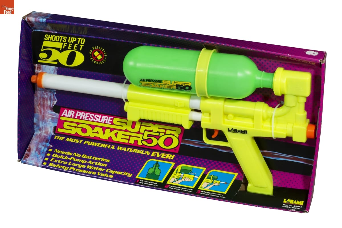 Super Soaker 50 Water Gun, 1991-1992 Purple and pink box containing large yellow and green water gun; also contains text