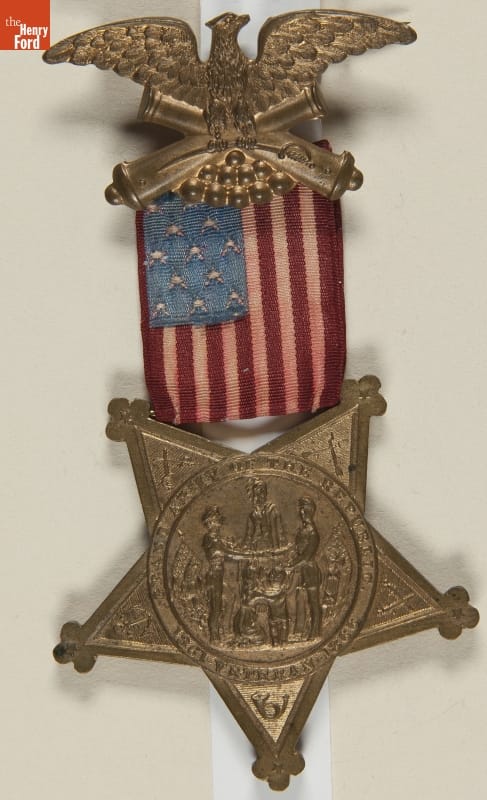 Grand Army of the Republic (G.A.R.) Membership Badge, 1883-1886 Badge with metal eagle and top and star with image and text at bottom; small U.S. flag in middle