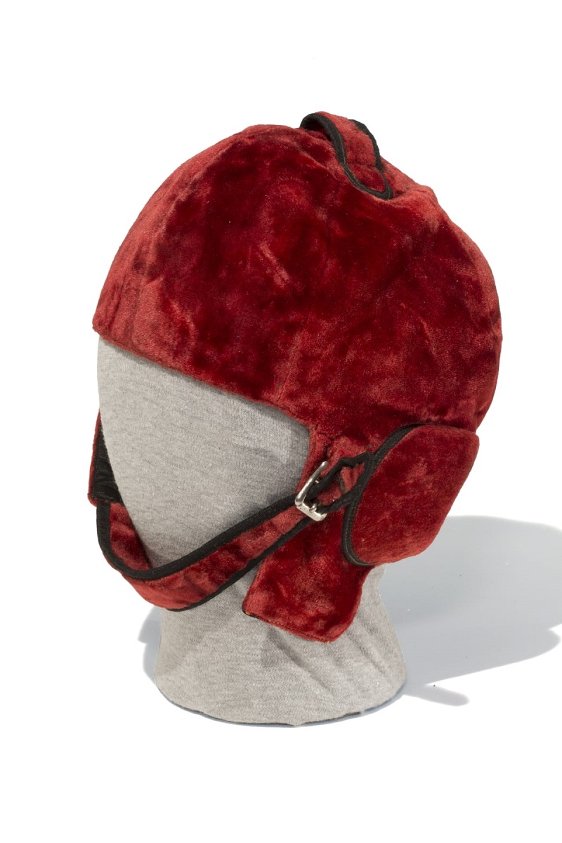 Brick-red velvet helmet with chin strap and ear flaps on mannequin head
