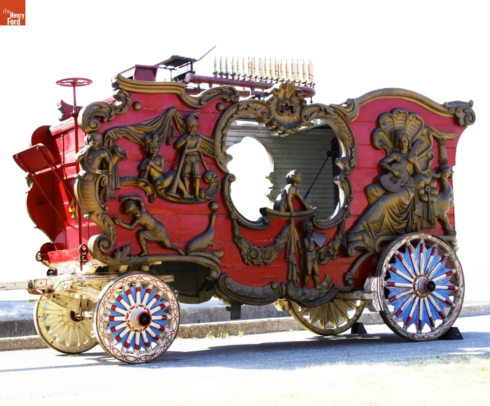 Calliope Circus Wagon, 1917 Large red wagon with colorful wheels, elaborately carved gold figures, and an open cut-out on either side