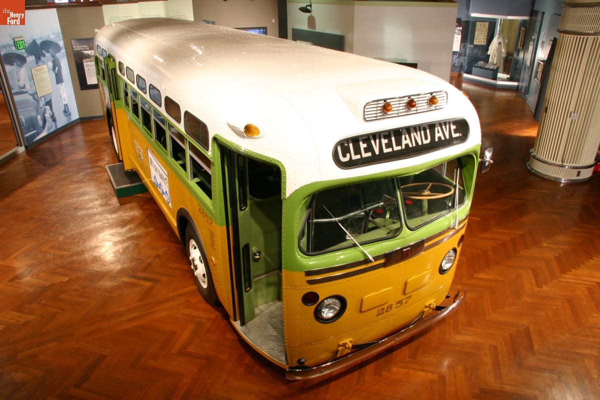 Angled, aerial view of gold, green, and white bus in museum exhibit