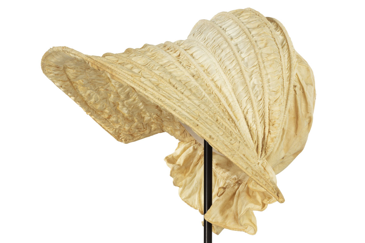 Calash Bonnet, 1830-1839 Off-white bonnet with rows of boning and shirred fabric between them; ruffle at neck