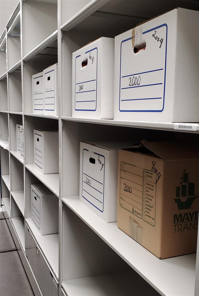 Catalogued ornaments awaiting delivery to the Photo Studio. Cardboard boxes on shelves