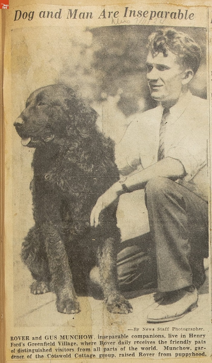 Newspaper clipping with photo of man kneeling next to seated large black dog; also contains text caption