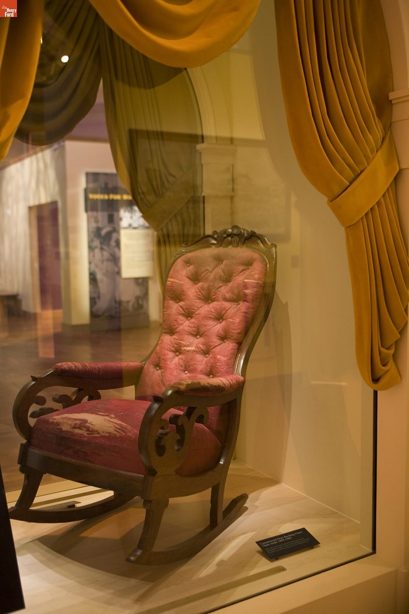 Chair Used by Abraham Lincoln at Ford's Theatre, on Exhibit at Henry Ford Museum, June 2007 / Photographed by Michelle Andonian Red upholstered rocking chair in glass case surrounded by mustard yellow curtains