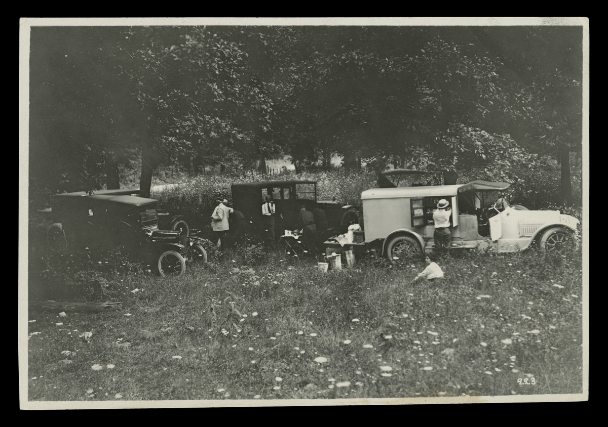 "Vagabonds" Camping Trip Caravan Stopped in a Field, 1921 Several cars in a field with people by and near them