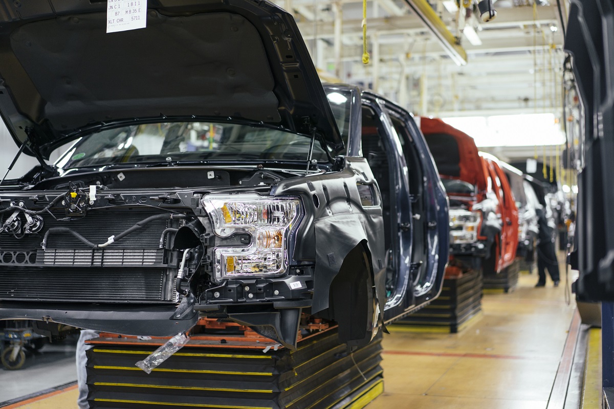 Ford F-150 Truck Assembly at the Rouge Partially assembled truck cabs on an assembly line; a person works on one in the distance