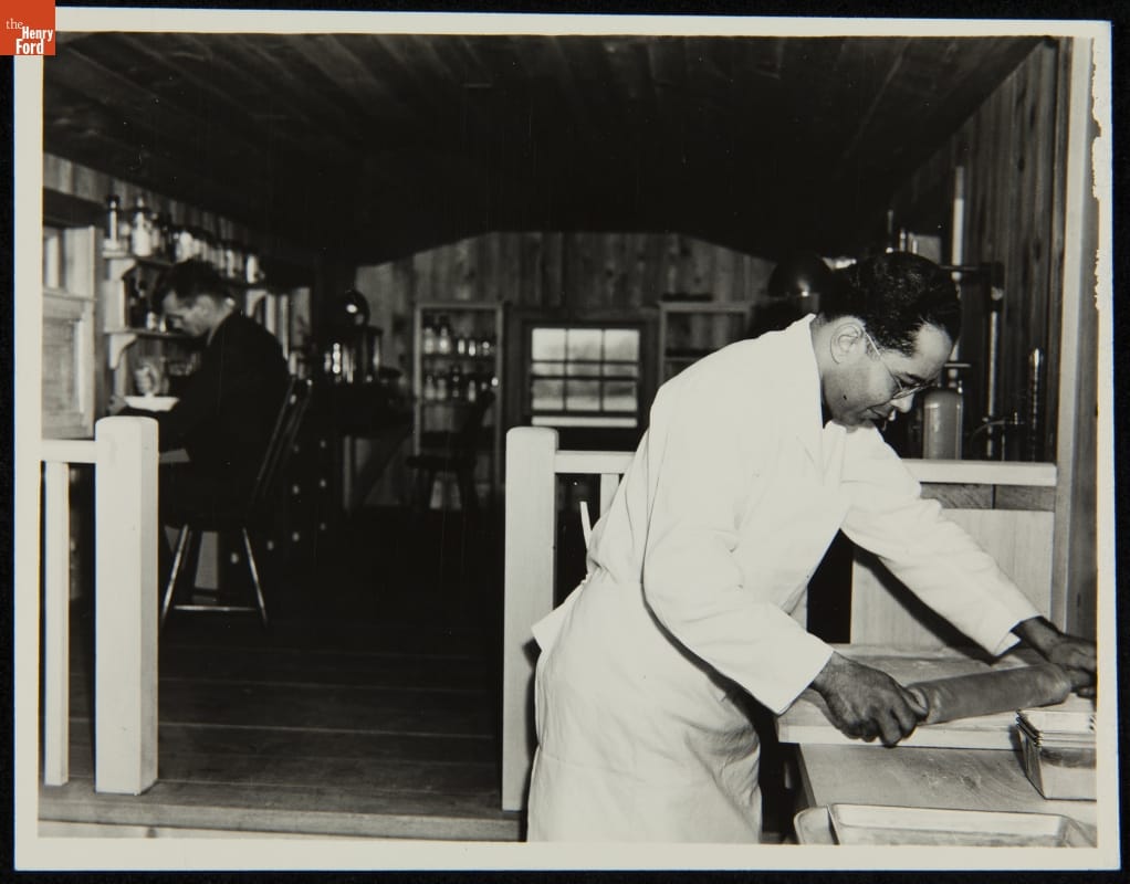 Worker Making Soybean Bread inside the Soybean Laboratory in Greenfield Village, Dearborn, Michigan, circa 1935 Man in white apron works with rolling pin while another man in background works with a mortar and pestle