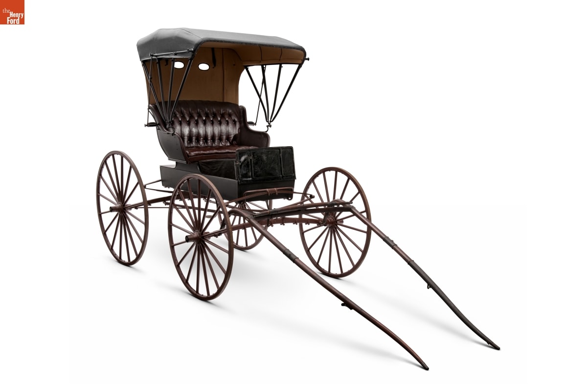 Noyes Piano Box Buggy, circa 1910 Small square buggy with four large wooden wheels and cushioned seat covered with a canopy