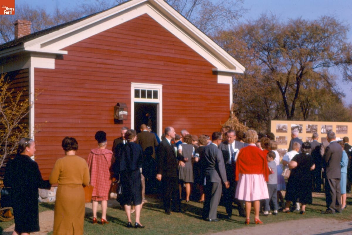 Dedication of Dr. Howard's Office in Greenfield Village, October 1963 Group of people mingle outside a small, red, wooden building
