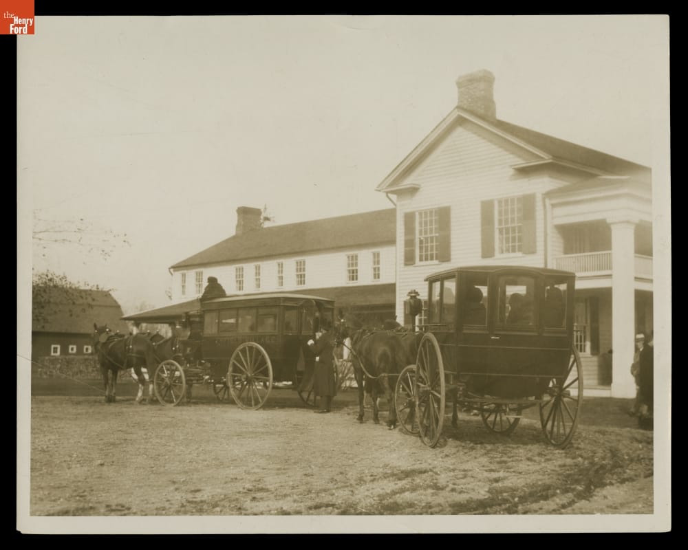 Horse-Drawn Carriages outside Eagle Tavern, Greenfield Village, 1929-1950 Enclosed carriages drawn by horses outside a two-story building