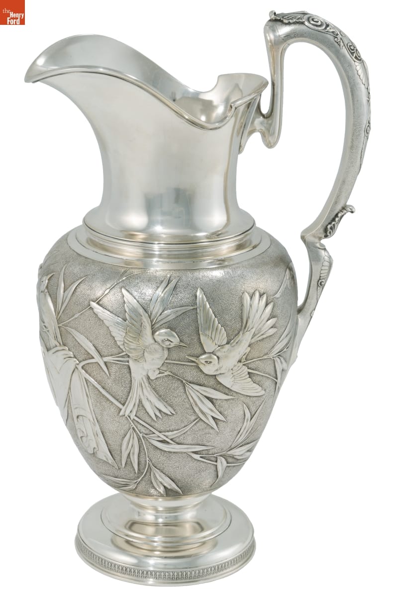 Pitcher, 1870-1875 Elaborate, tall silver pitcher with engraved birds and foliage on body
