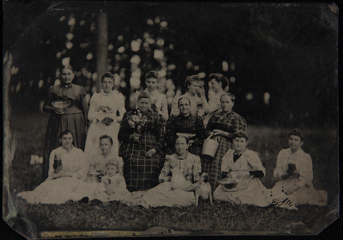 Group of Women at a Picnic, circa 1895 Women of various ages posed on a lawn, each holding tableware items
