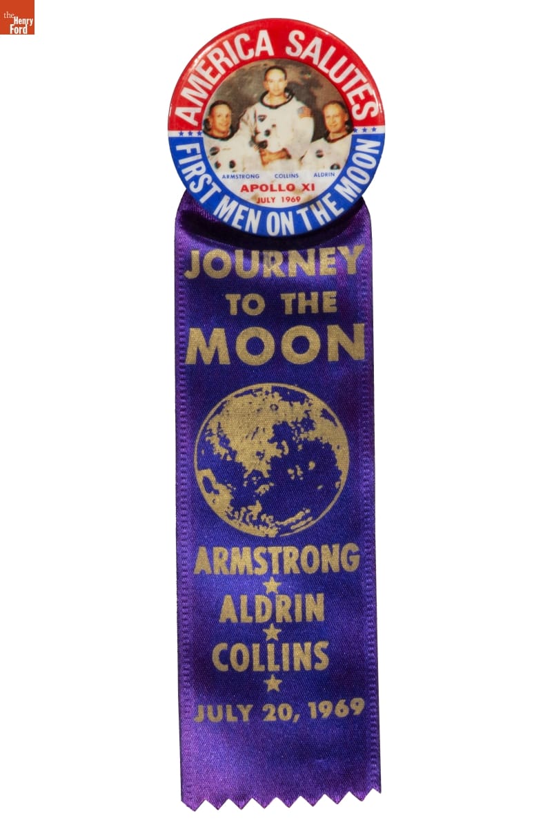 "First Men on the Moon" Button and Ribbon, circa 1969 Blue satin ribbon with gold text, topped by medallion with photo of three astronauts inside blue and red semicircles containing text