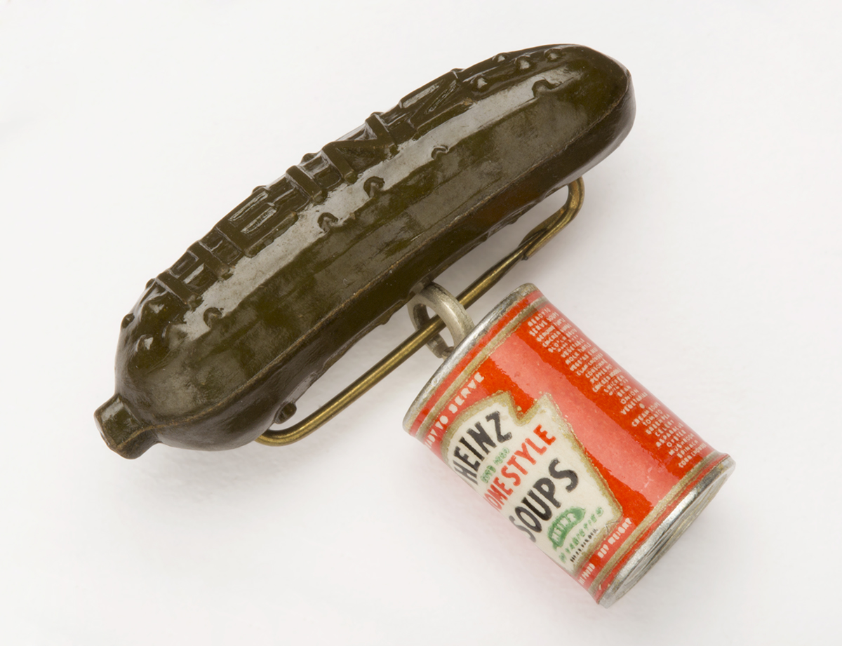 Heinz Pickle Pin "Heinz Homestyle Soups," 1939-1940 Pin in the shape of a green pickle with a red-and-white can of soup dangling from it; also contains text