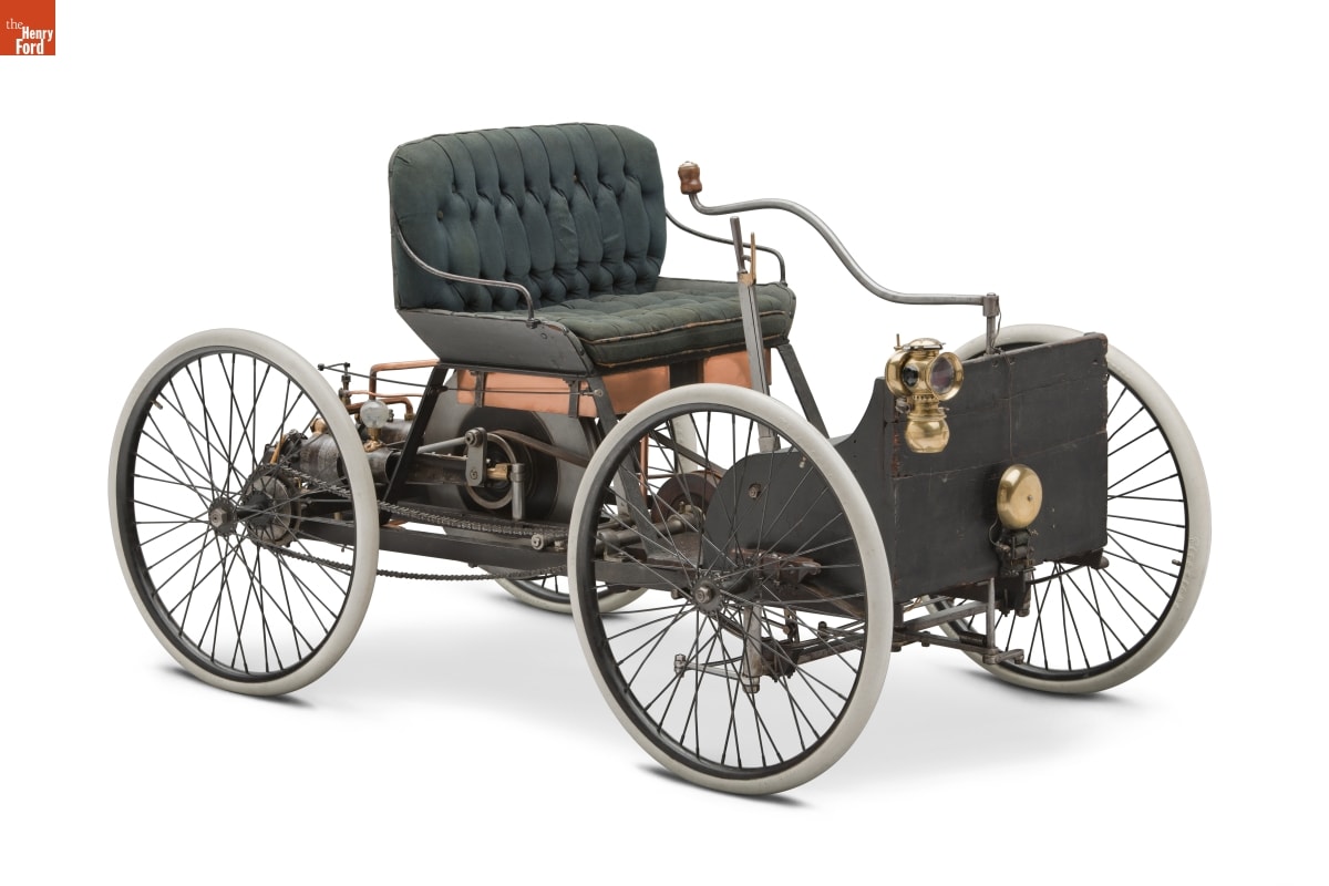 1896 Ford Quadricycle Runabout, First Car Built by Henry Ford Green cushioned seat on top of platform containing mechanics with four wheels and rudder